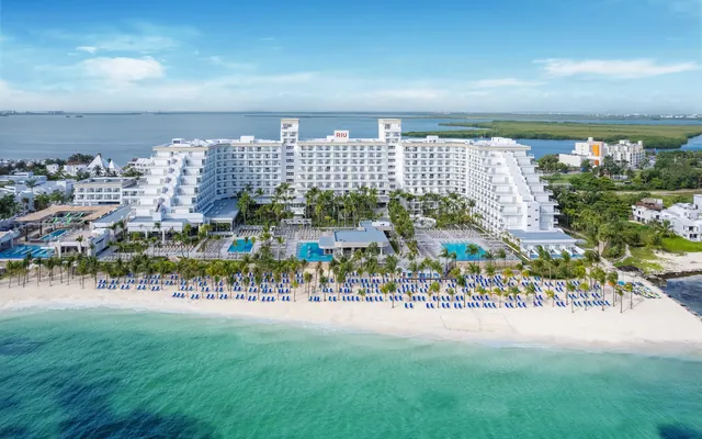 Vista aérea de un hotel todo incluido frente al mar turquesa en Cancún